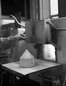 821169 Afbeelding van een proefneming met een oven in het laboratorium van de N.V. Nederlandse Staalfabrieken DEMKA ...